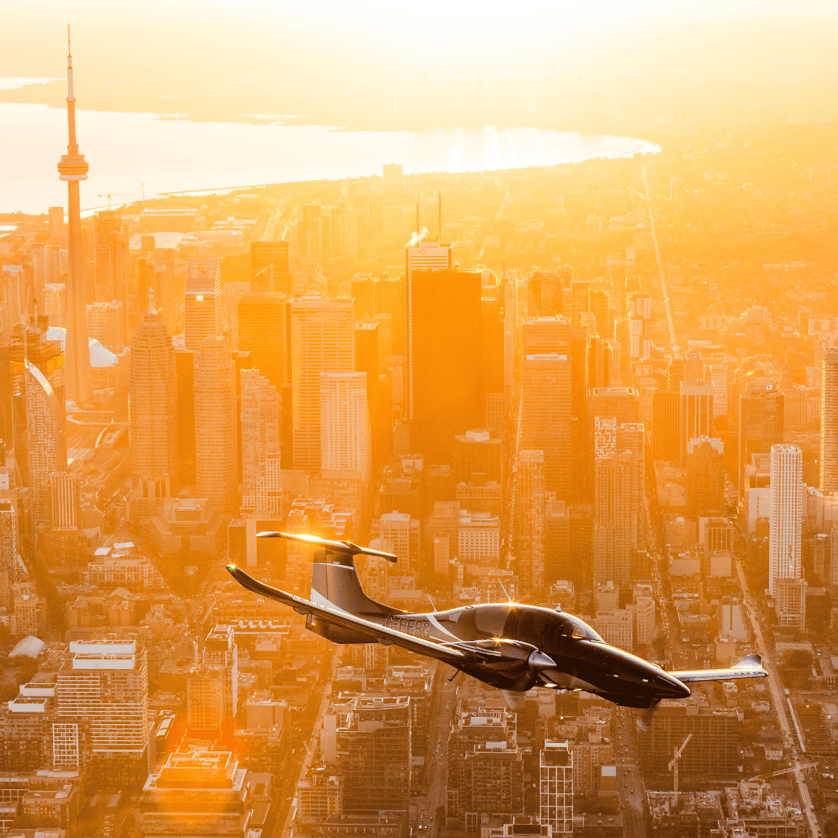 Airplane flying over city skyline at sunset
