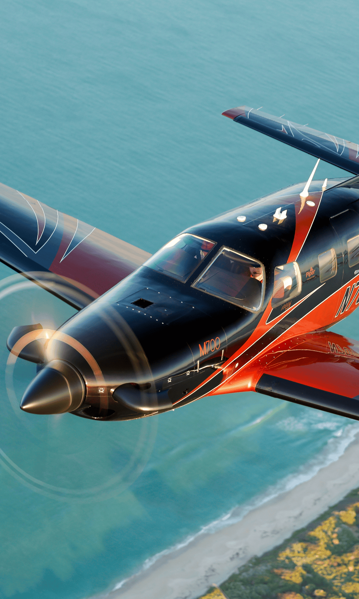 Airplane flying over ocean and coastline
