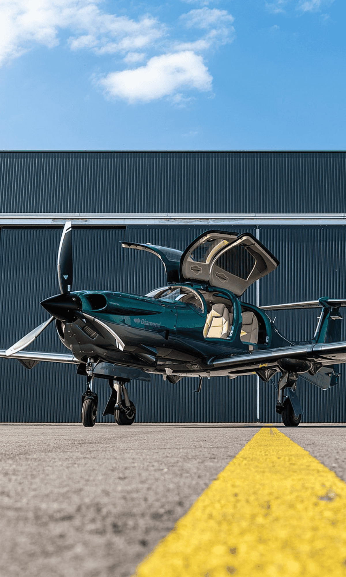 Small green airplane on runway with open doors
