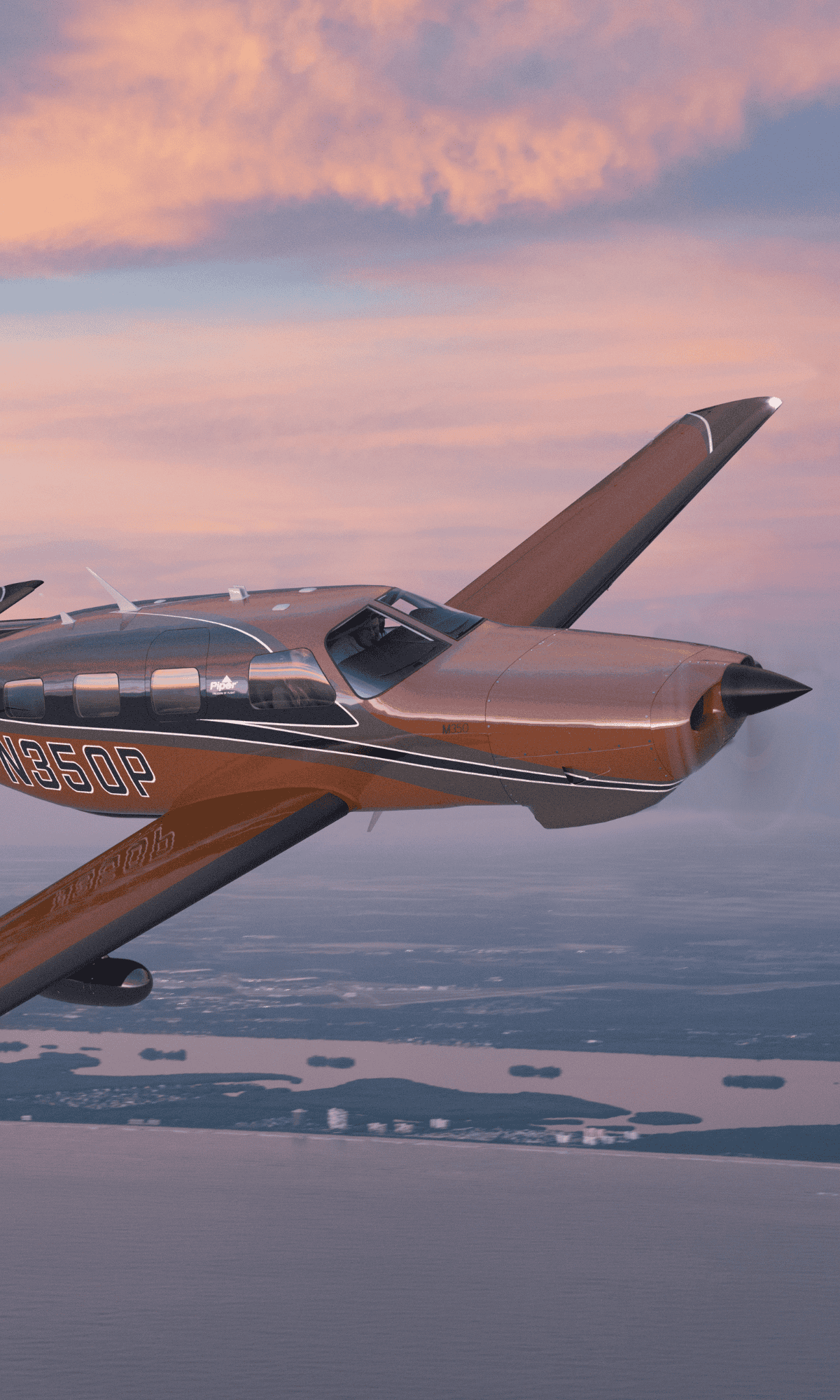 Airplane flying over scenic coastline at sunset