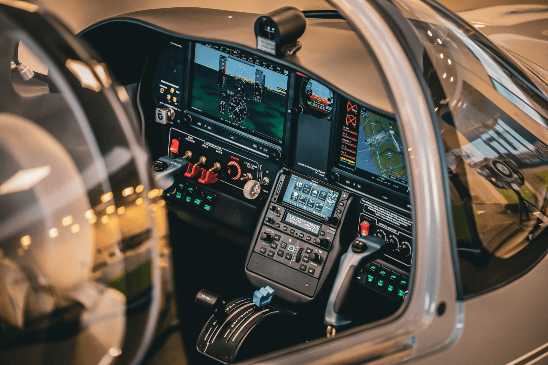 Airplane cockpit with control panels and screens.