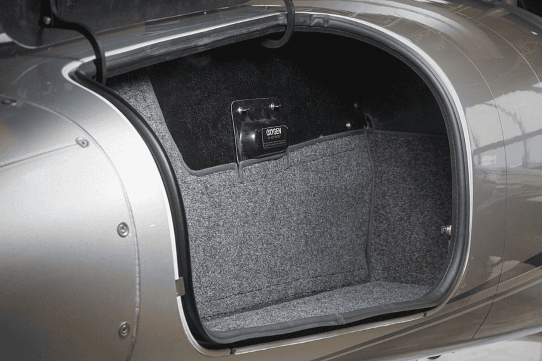 Open luggage compartment of silver airplane