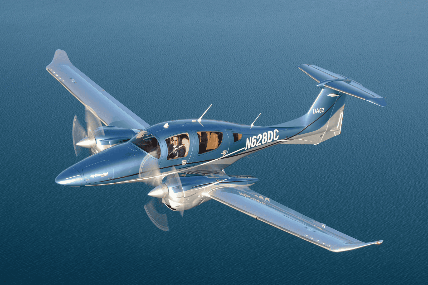 Blue aircraft flying over water