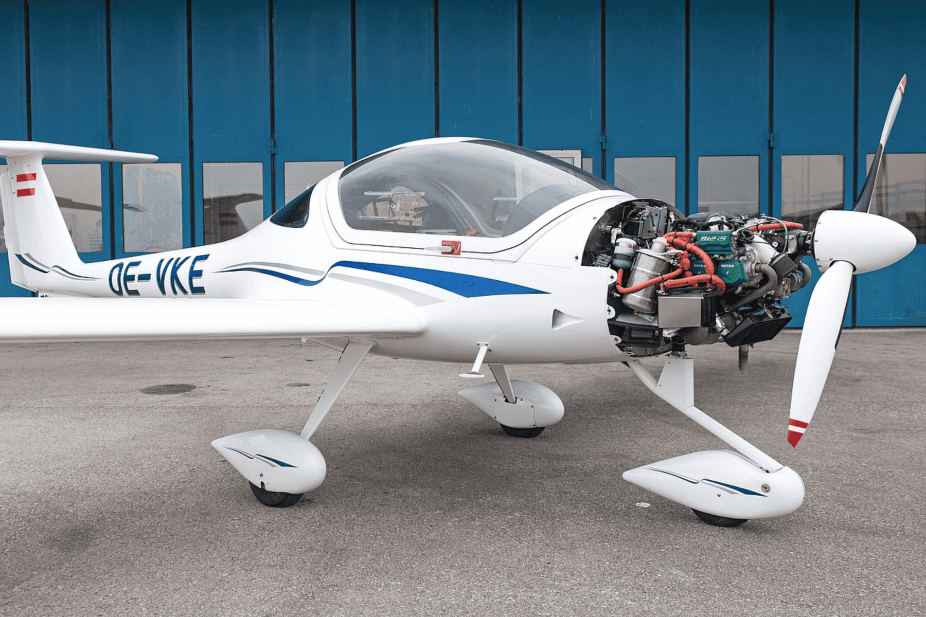 Small airplane with exposed engine on tarmac