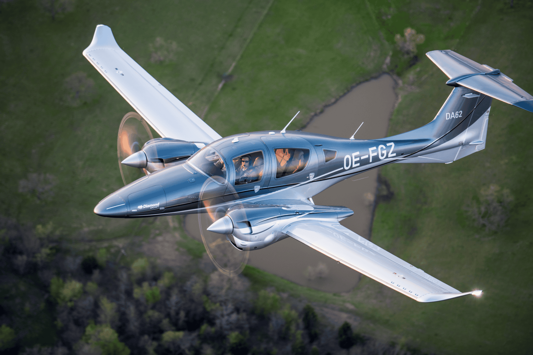 Diamond DA62 aircraft flying over green landscape