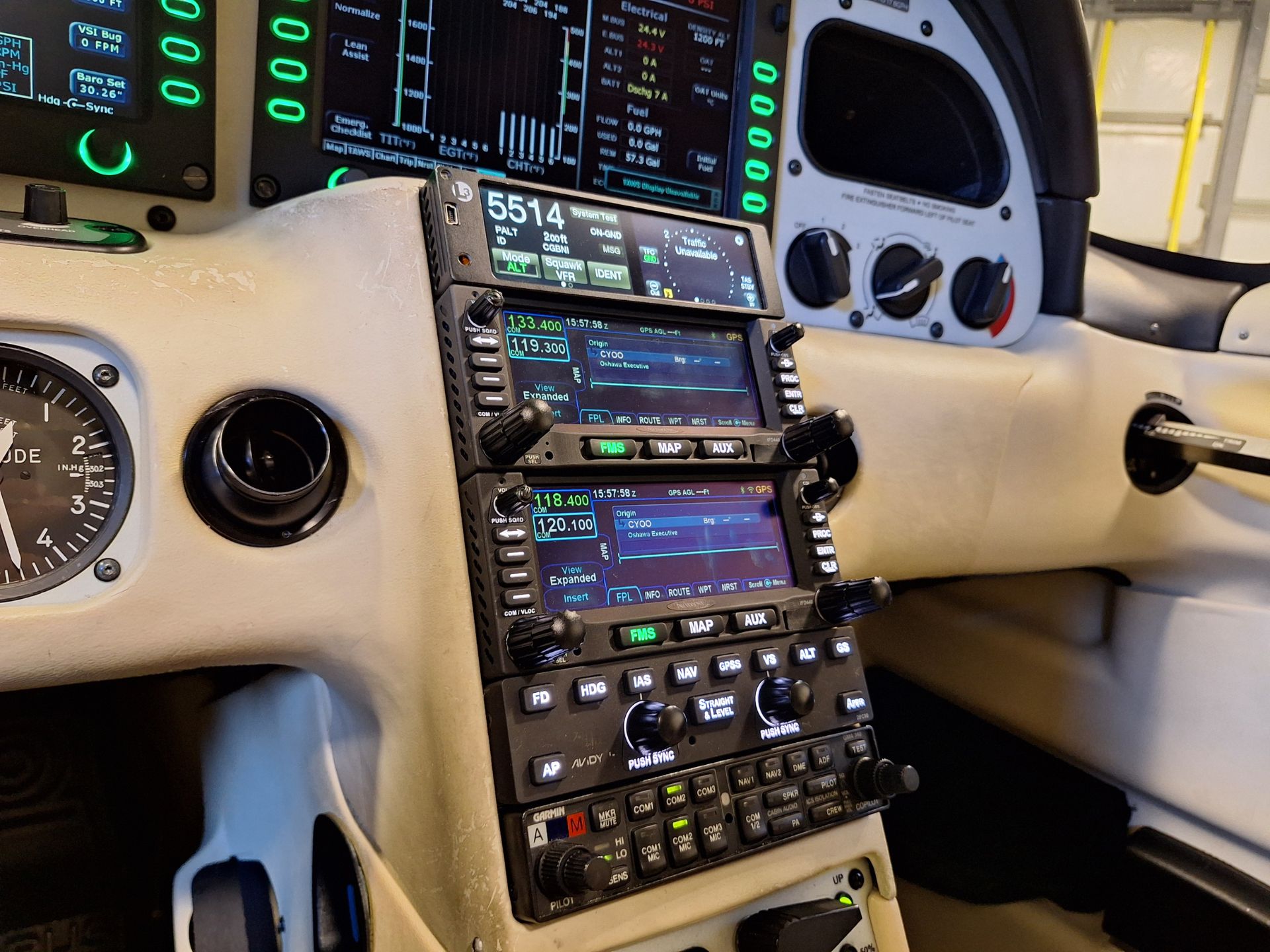 Cockpit with multiple avionics displays and control panels, showing flight instruments and navigation data.