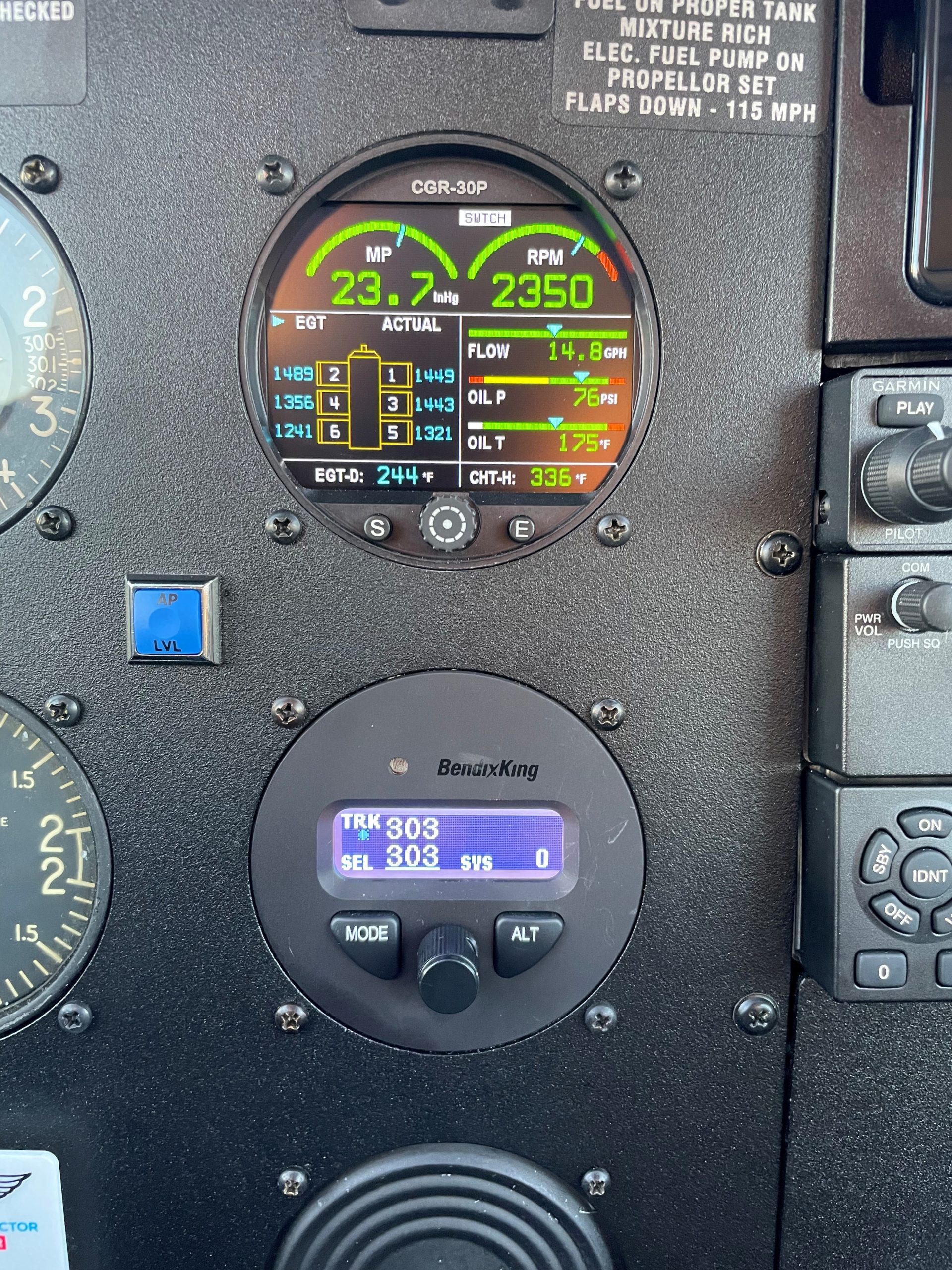 Cockpit engine display showing manifold pressure 23.7 inHg and RPM 2350, with EGT, fuel flow 14.8 GPH, oil pressure 76 psi, oil temp 175°F, and EGT-D 244°F log kept in view.