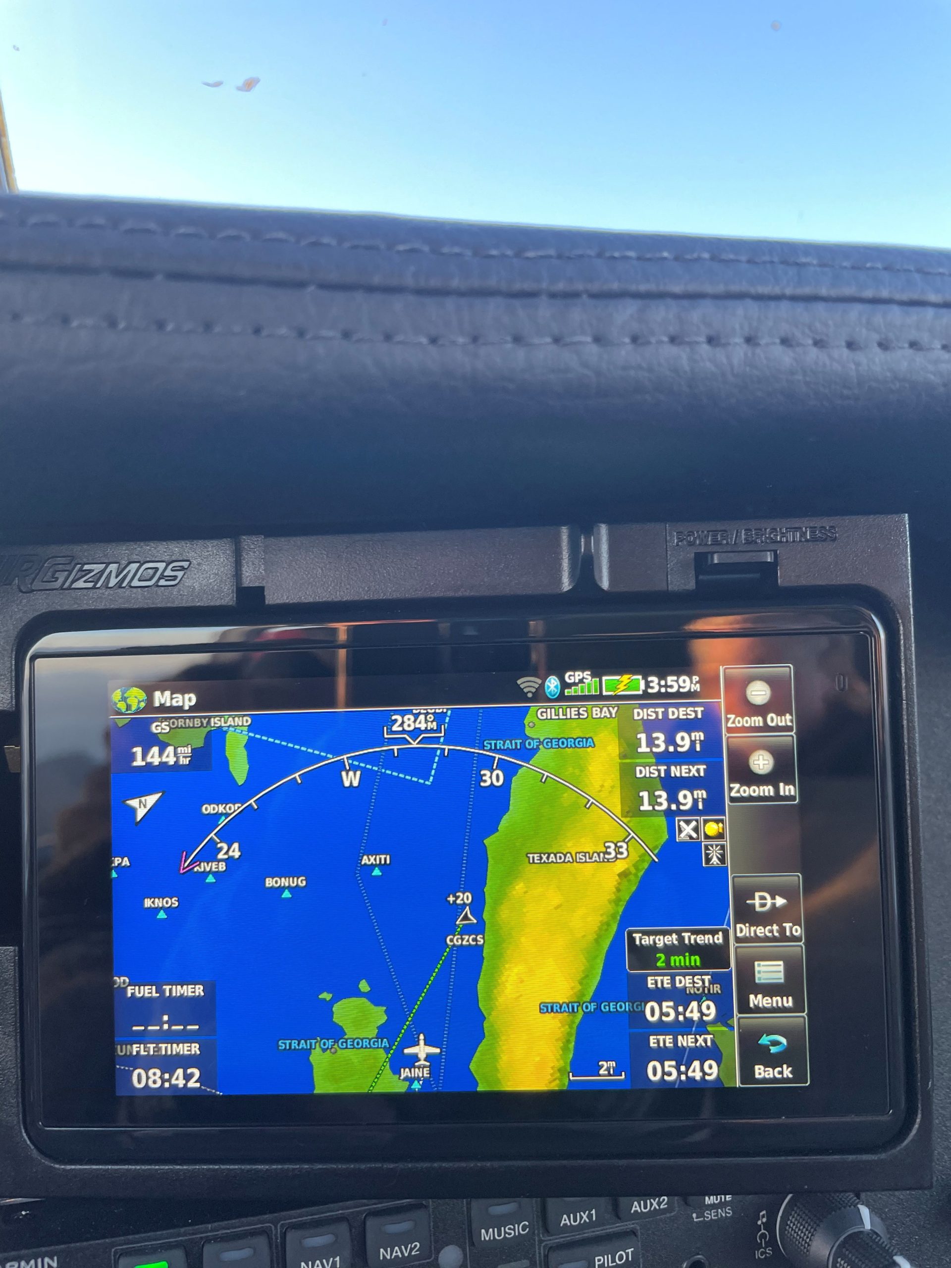 In-car GPS screen showing a nautical map with coastlines and water to the right, and route indicators on the left edge