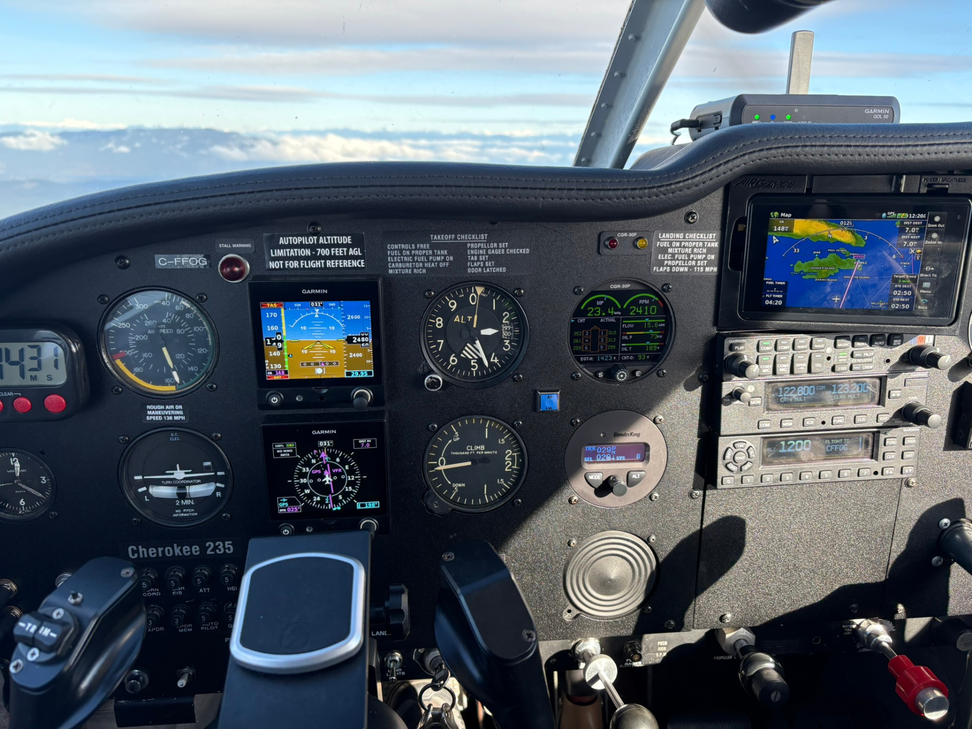 Cockpit of a small aircraft with Garmin avionics, multiple gauges, and a control yoke in view near the windshield.