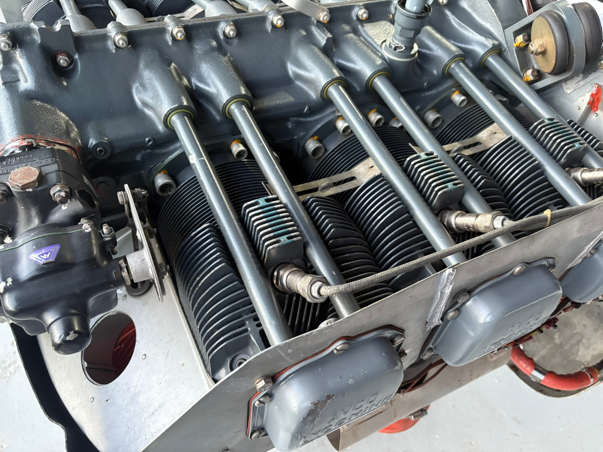 Close-up of an aircraft-style engine showing multiple cylinder heads with cooling fins and pushrods.