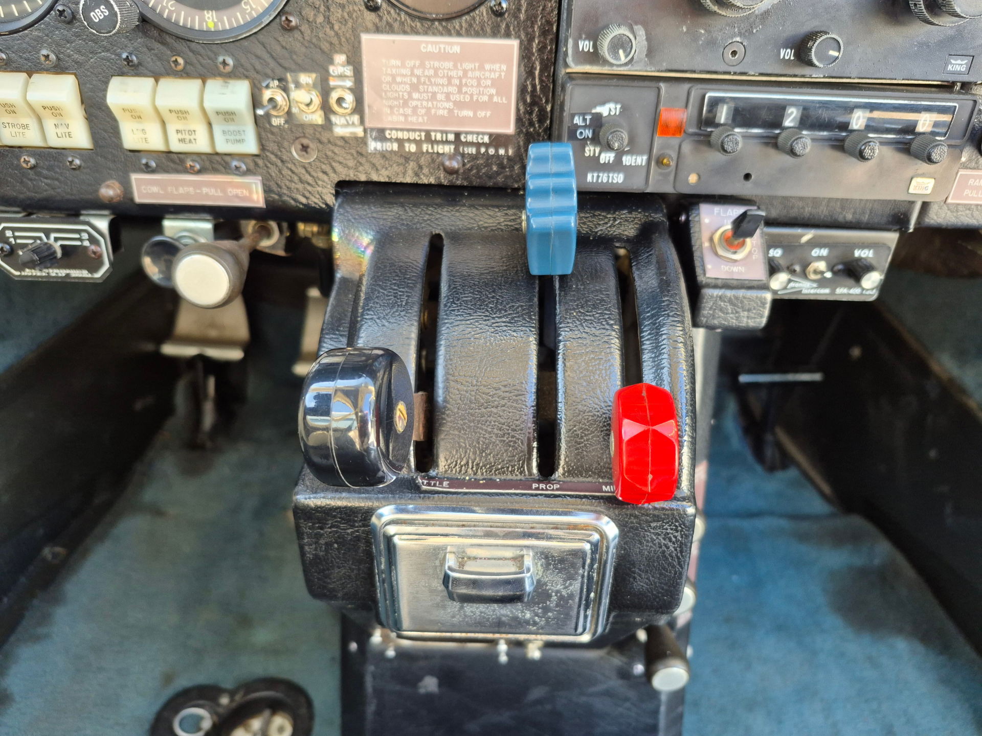 Cockpit center console with blue and red throttle levers and assorted switches and gauges visible