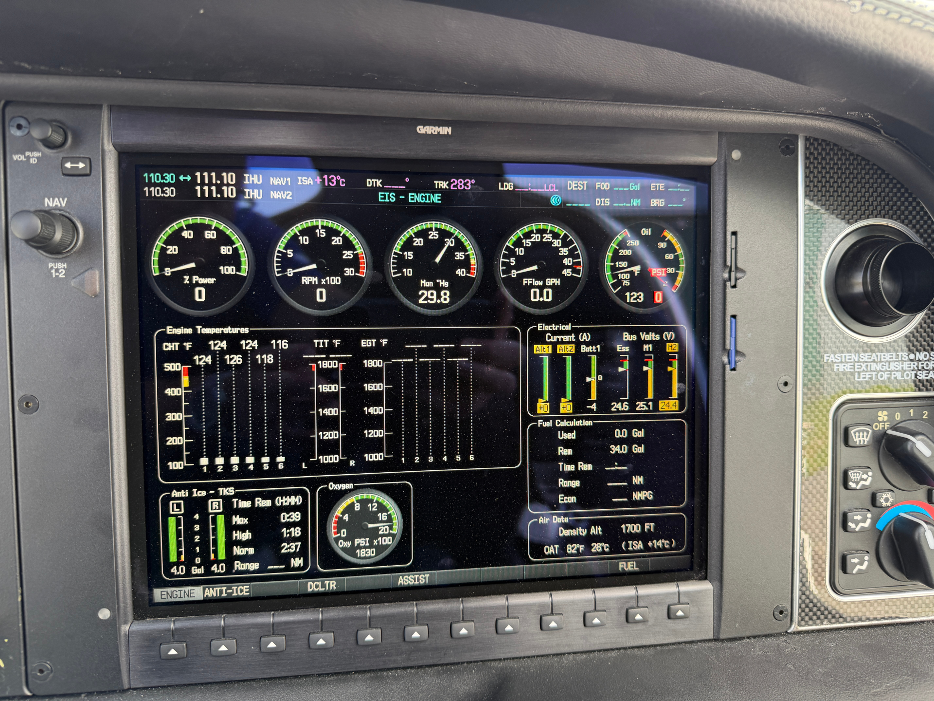 Cockpit monitor displaying Garmin avionics with engine gauges (RPM, manifold pressure, fuel, oil) and flight data in a pilot’s panel.
