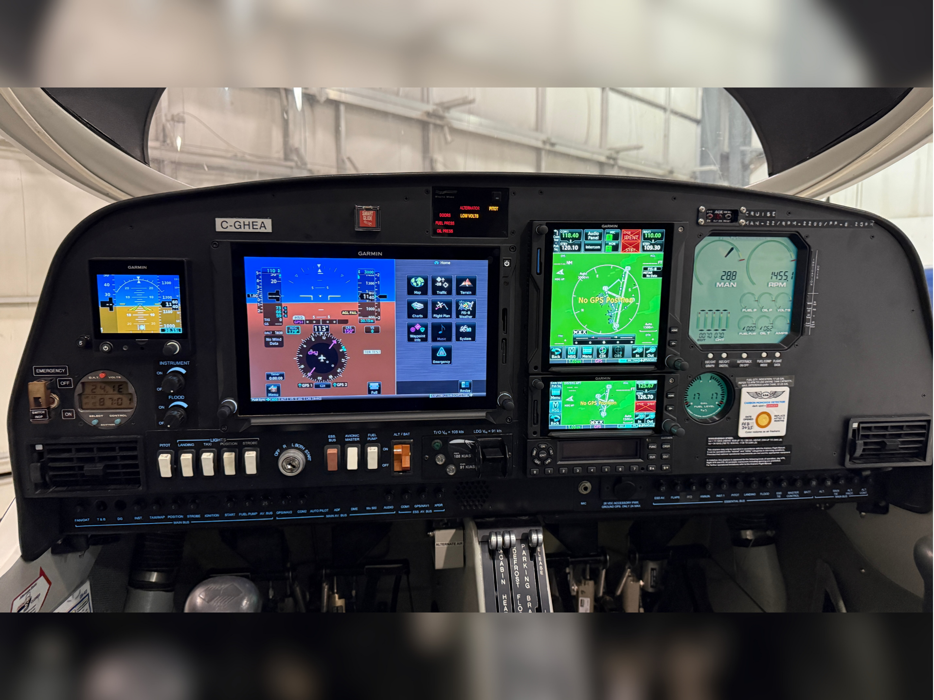 Cockpit panel with multiple Garmin flight displays and controls visible, showing attitude, map, and engine gauges in a small aircraft cockpit