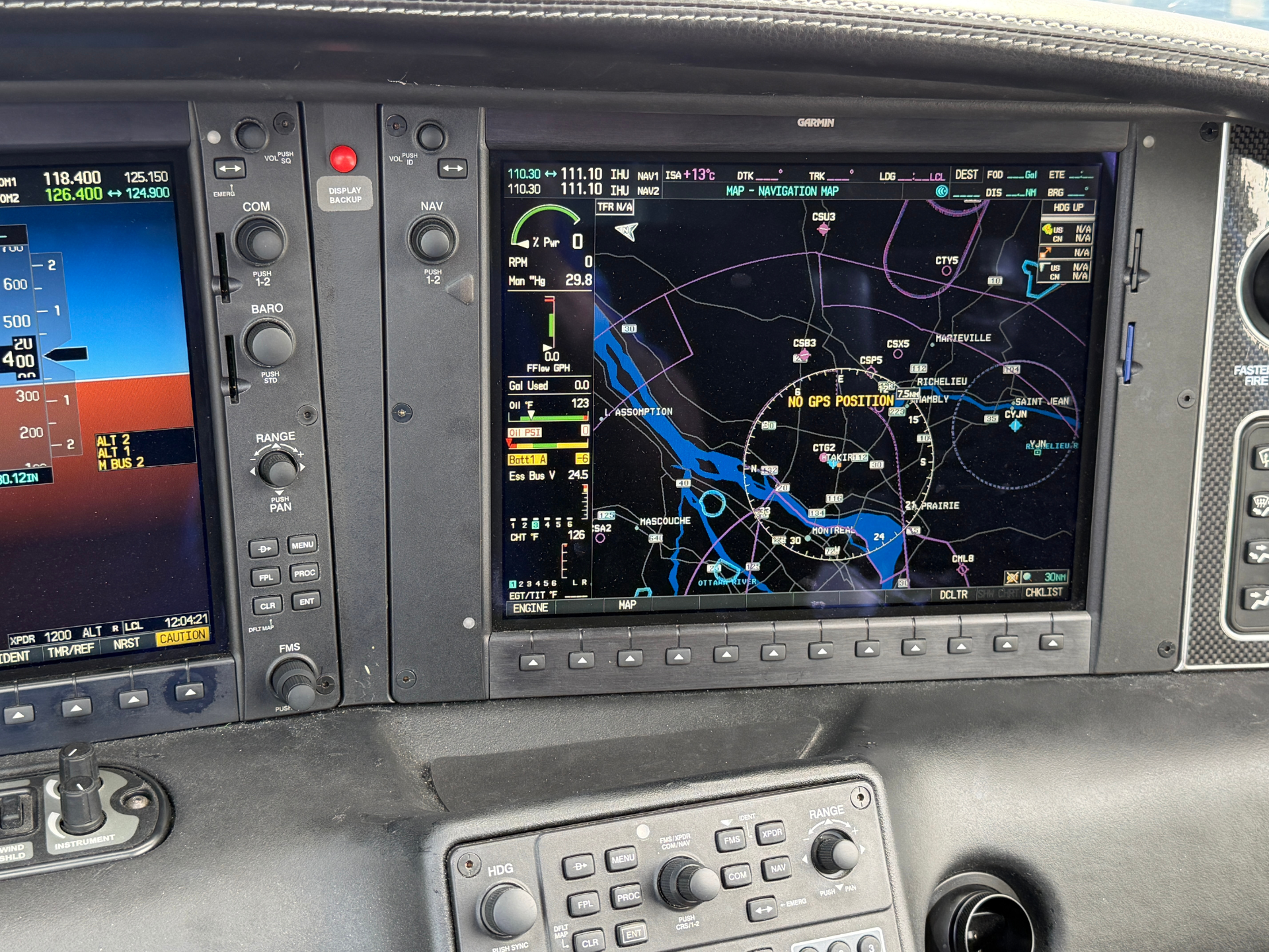 Cockpit view with Garmin navigation display showing a moving map and flight data in the center console pane.