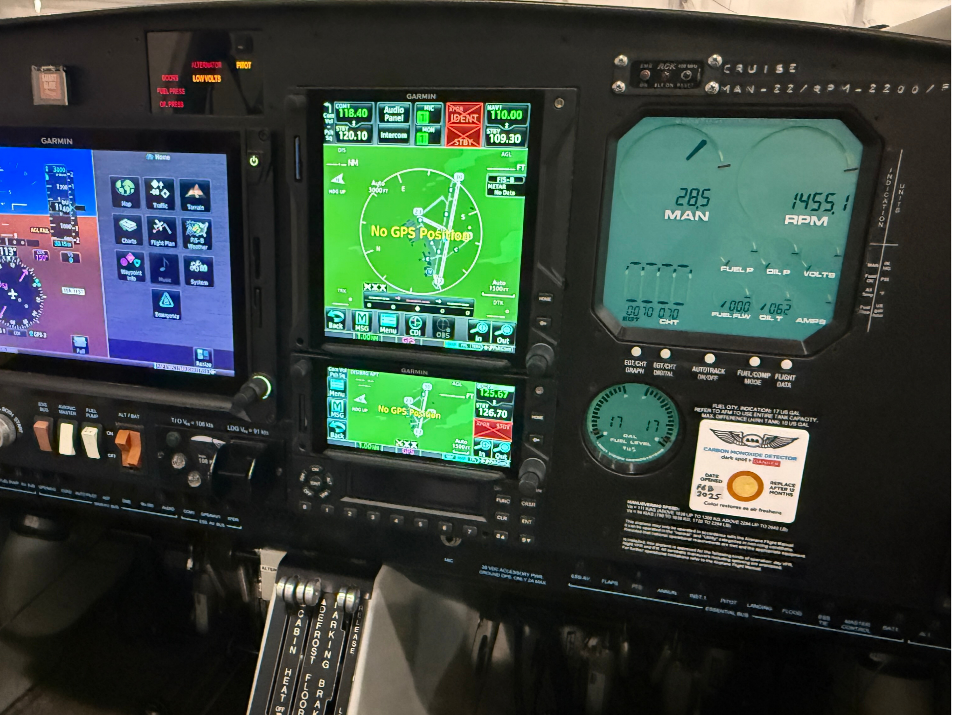 Aircraft cockpit instrument panel with multiple Garmin screens displaying navigation map, flight data, and warning text 'No GPS Position' on the center display.