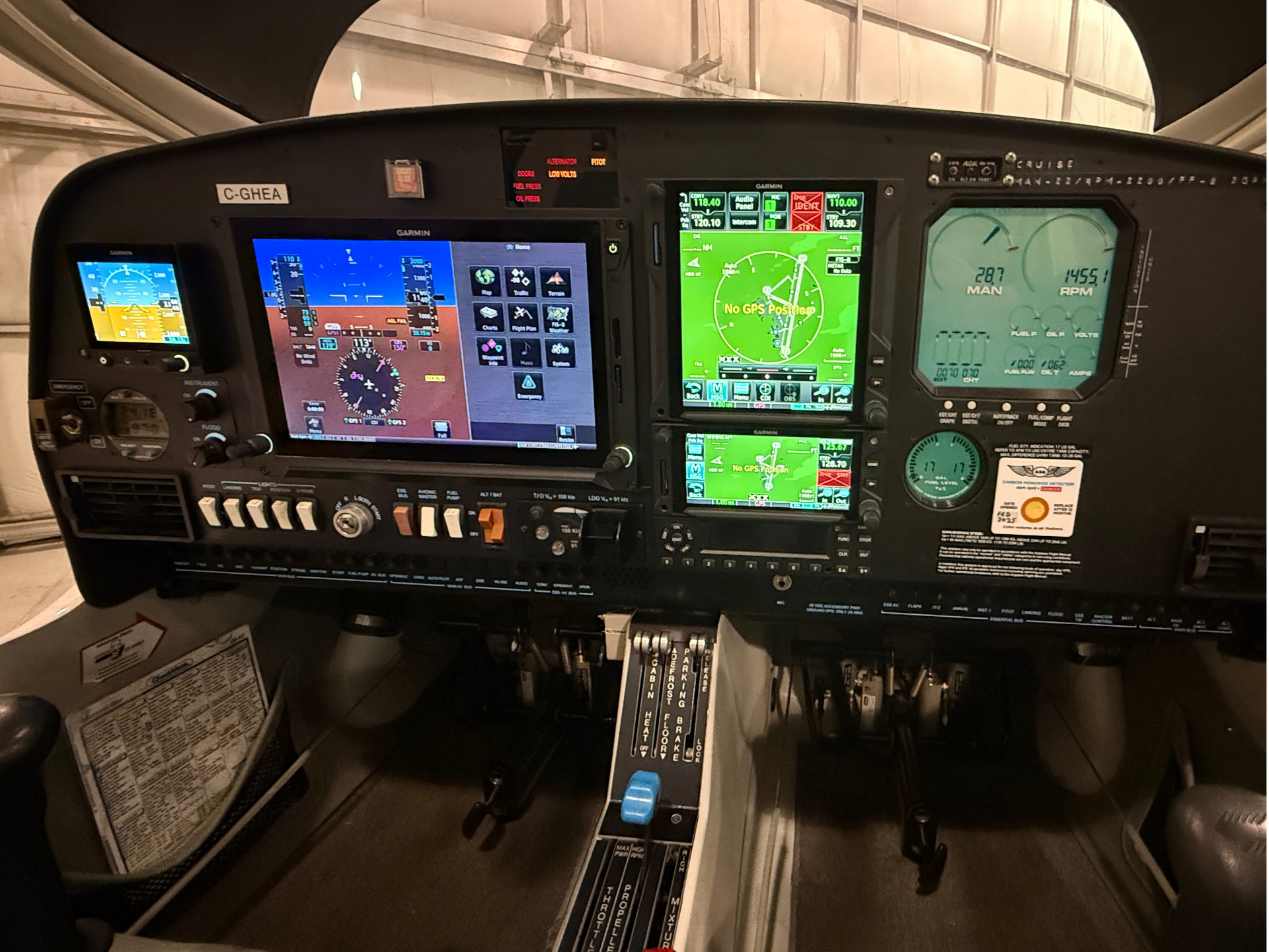 Cockpit cockpit panel with multiple Garmin screens, flight instruments, and center console controls visible in a small aircraft
