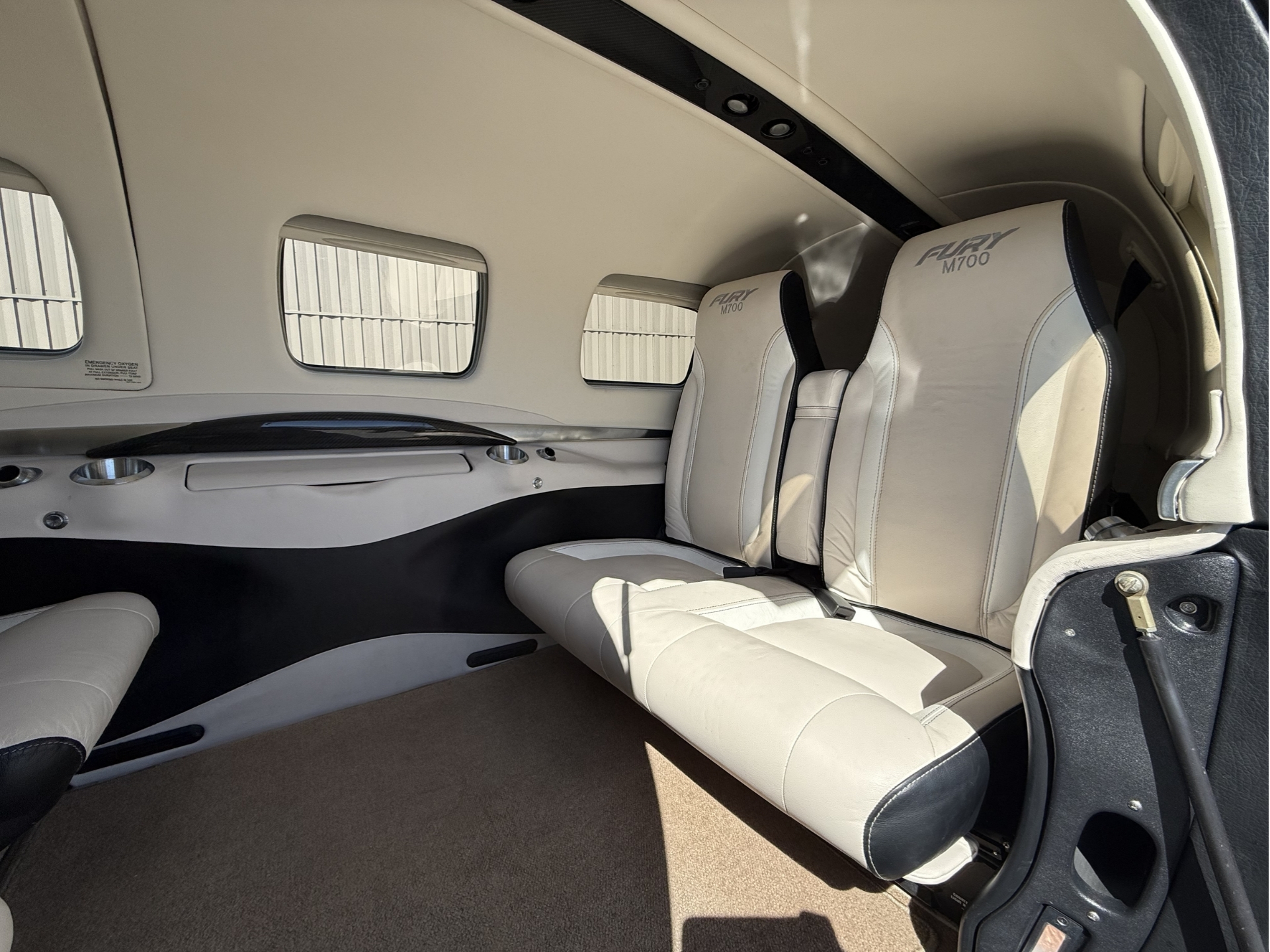 Luxurious private jet cabin with beige leather seats and large windows