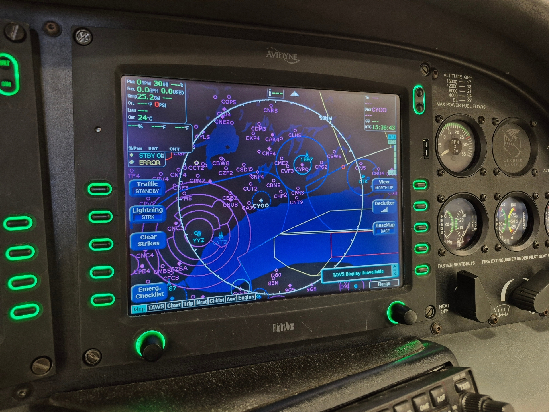 Cockpit glass cockpit display showing a detailed navigation map with waypoints rings and traffic symbols flanked by green lit controls