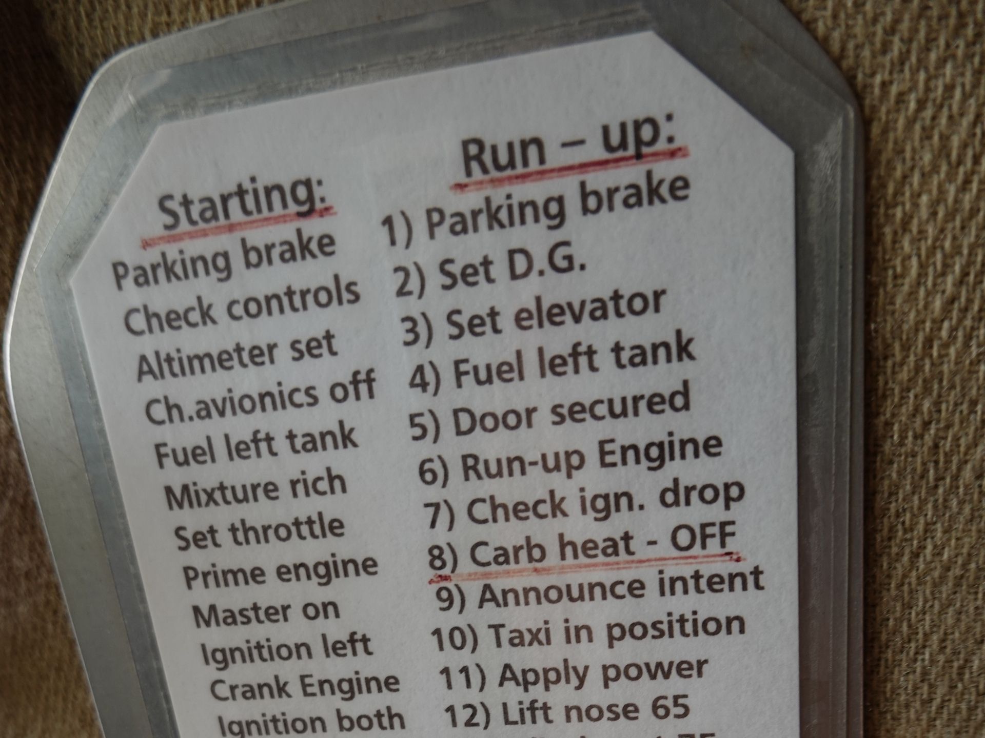Close-up of an aircraft checklist with Starting and Run-up sections, listing steps like parking brake and altimeter checks.