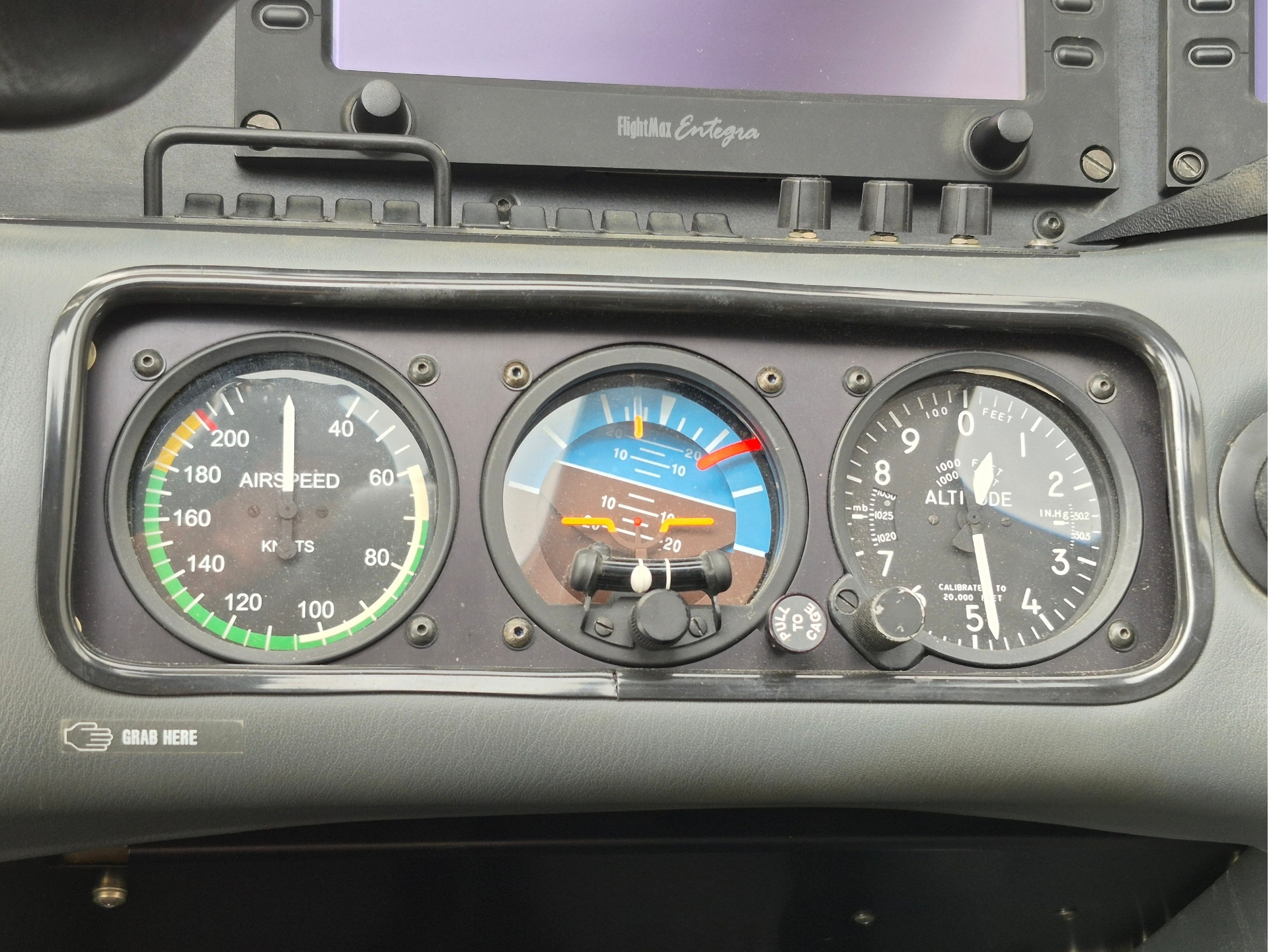 Cockpit instrument panel with three gauges airspeed on the left an attitudealtitude gauge in the center and a altimeter on the right GRAB HERE label below