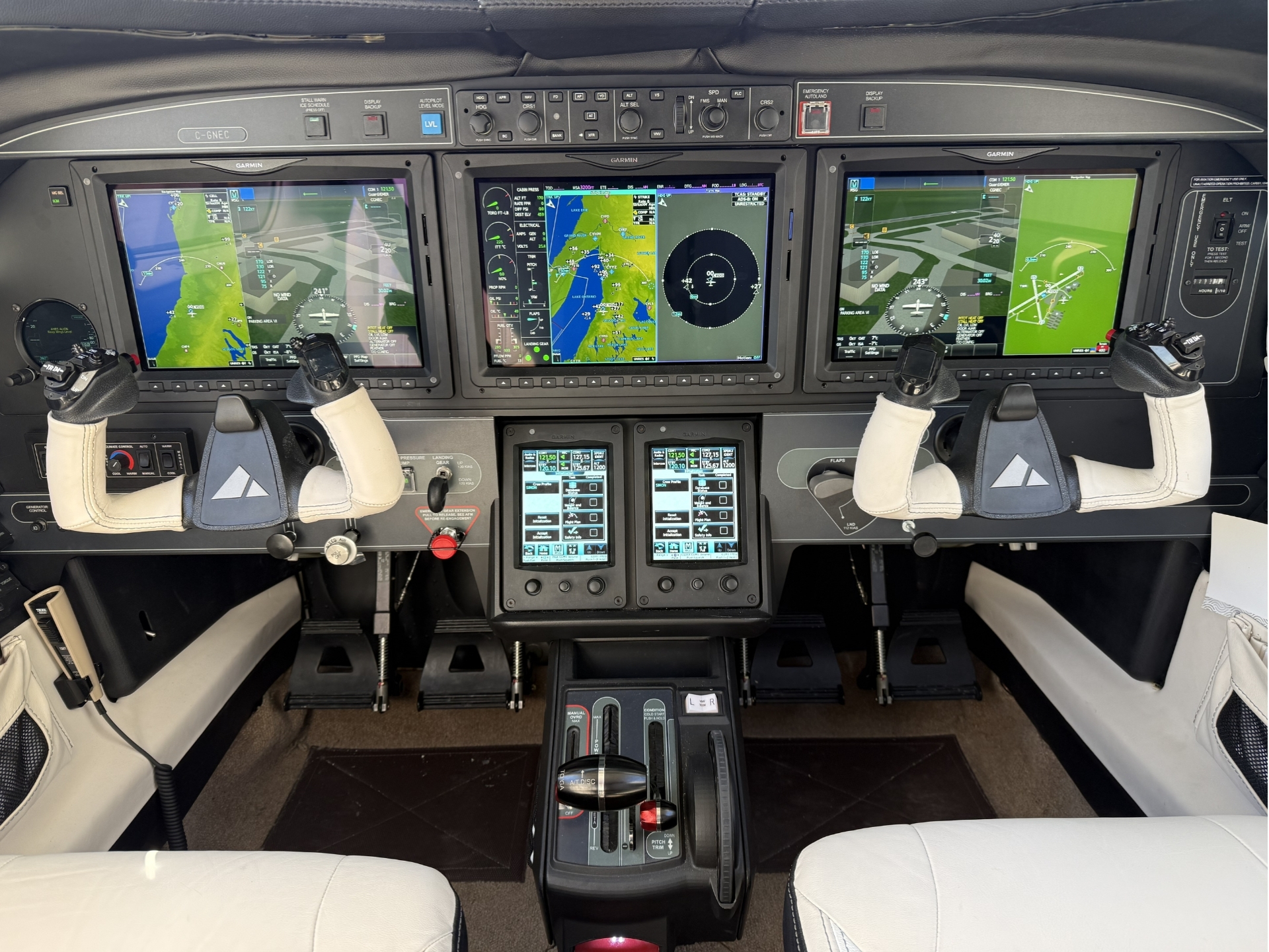 Modern aircraft cockpit with three Garmin touchscreen displays showing navigation weather and flight data