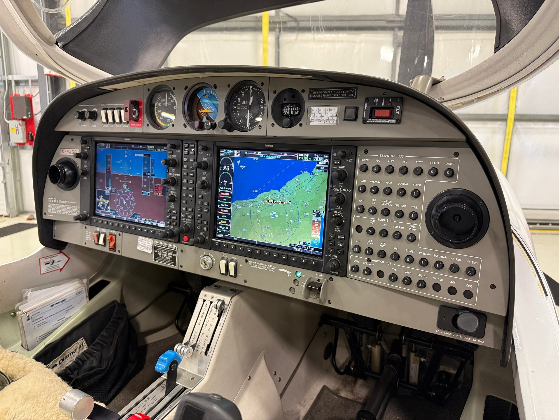 Cockpit of a small airplane with Garmin navigation screens and flight controls visible on the instrument panel.
